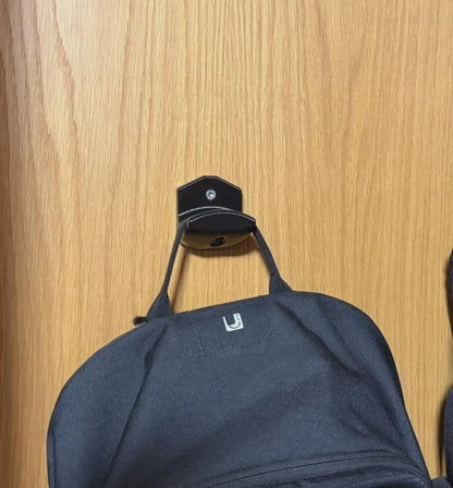 Wall-mounted hook holding a backpack