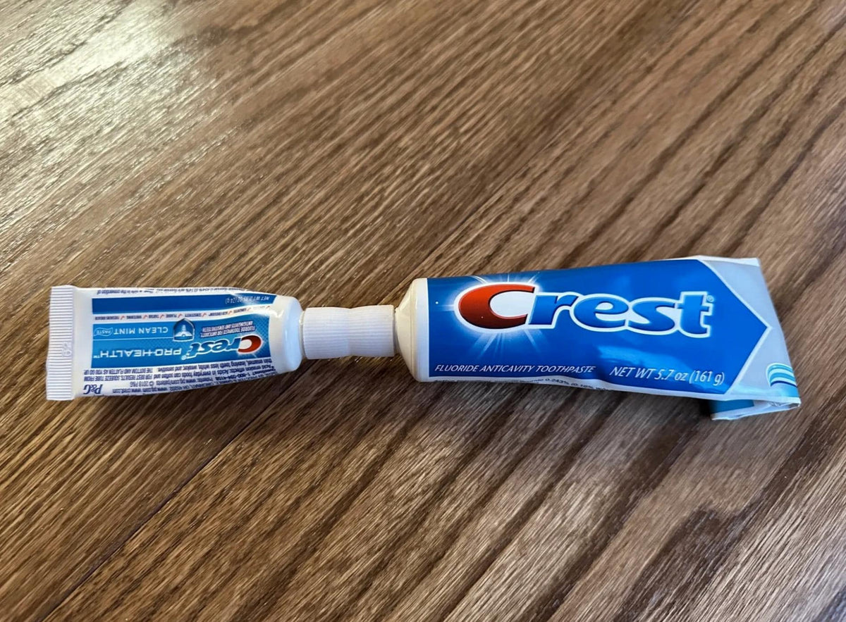 Travel toothpaste transfer adapter connecting a full-size and travel-size tube