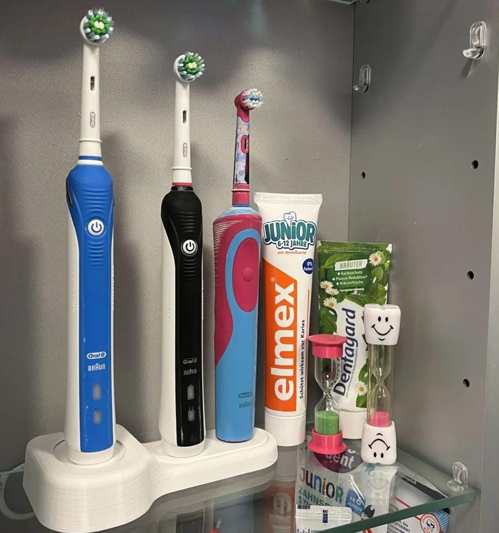 Oral-B toothbrush stand holding three electric toothbrushes