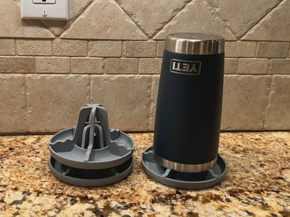 Stacked bottle drying racks beside a tumbler on a kitchen counter