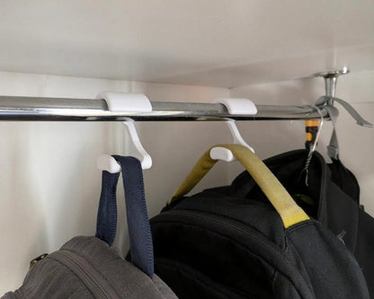 Backpack hanger hooks holding bags on a closet rod